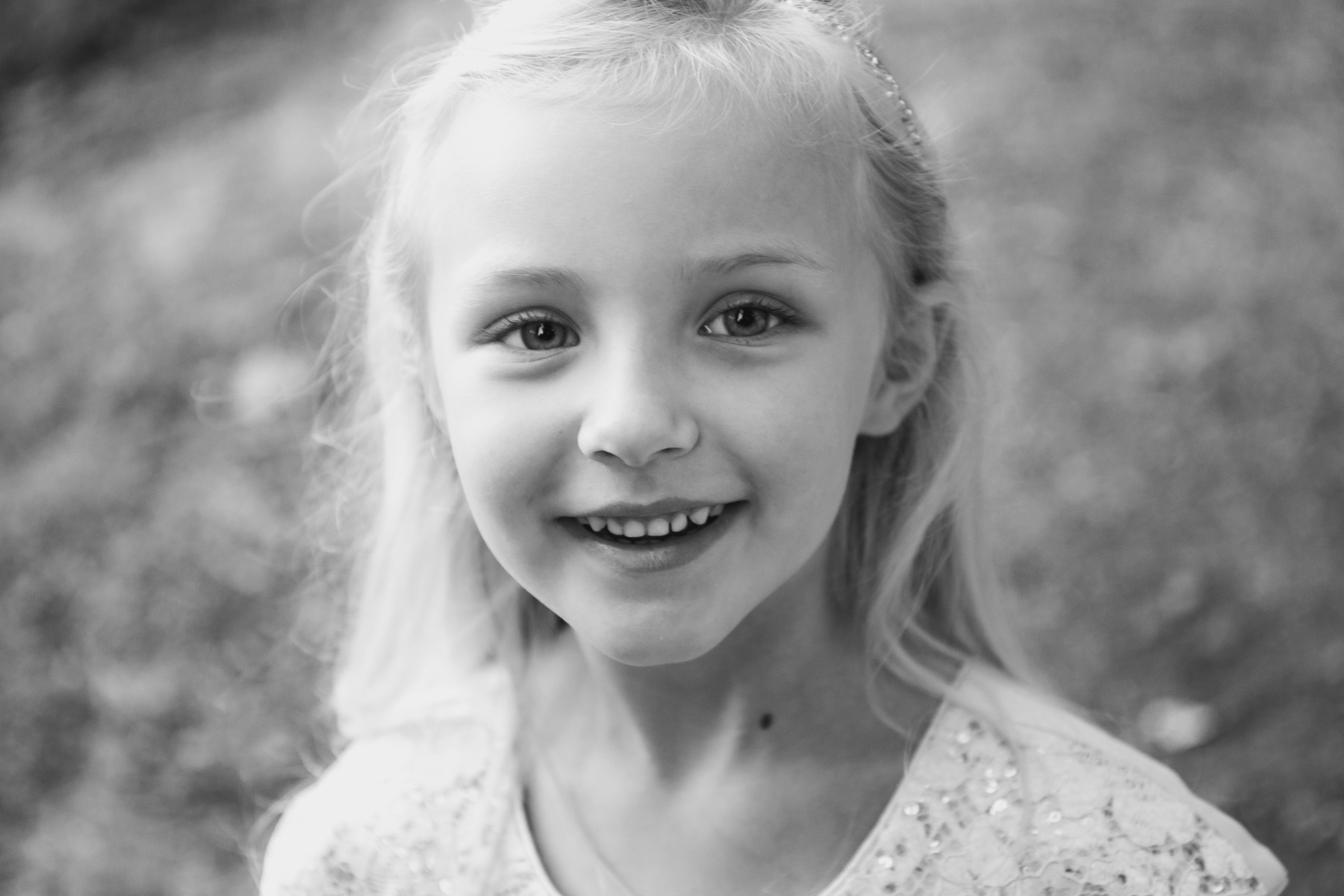 A black-and-white close-up portrait of Hazel, smiling softly